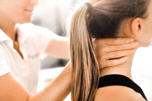 A person sitting on a couch using a smartphone with a visible hand brace on their thumb.